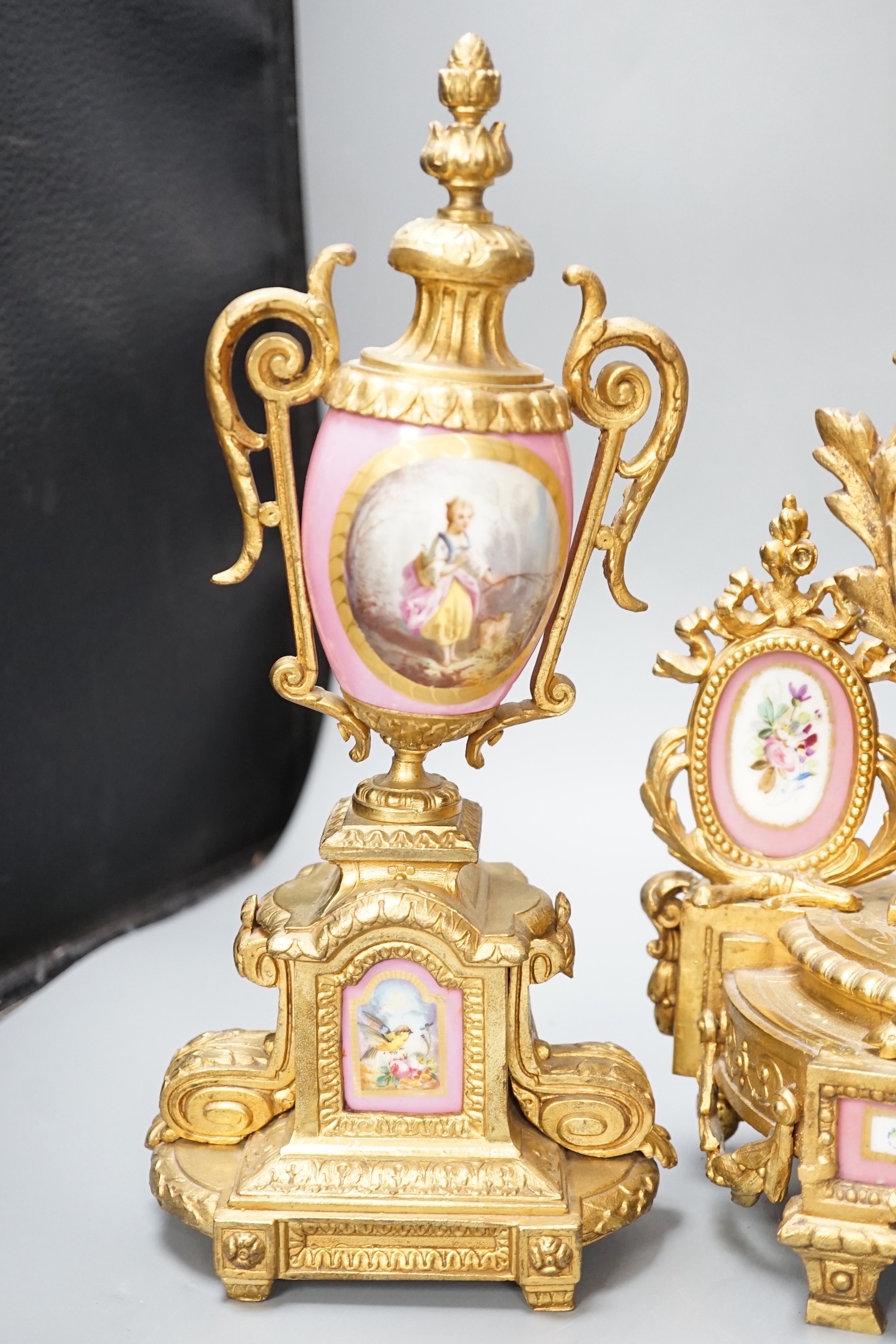 A French gilt metal and porcelain clock garniture. 36.5cm